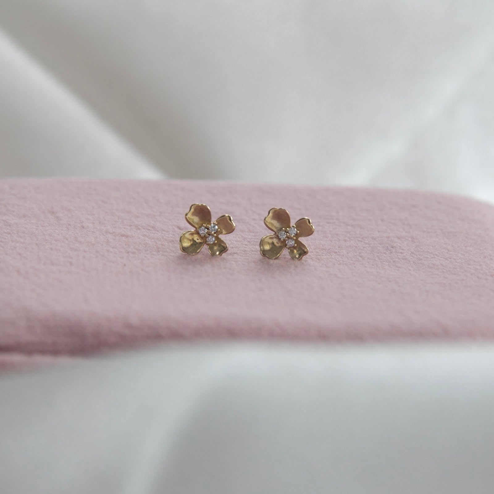 9 ct gold flower studs on a pink velvet box 