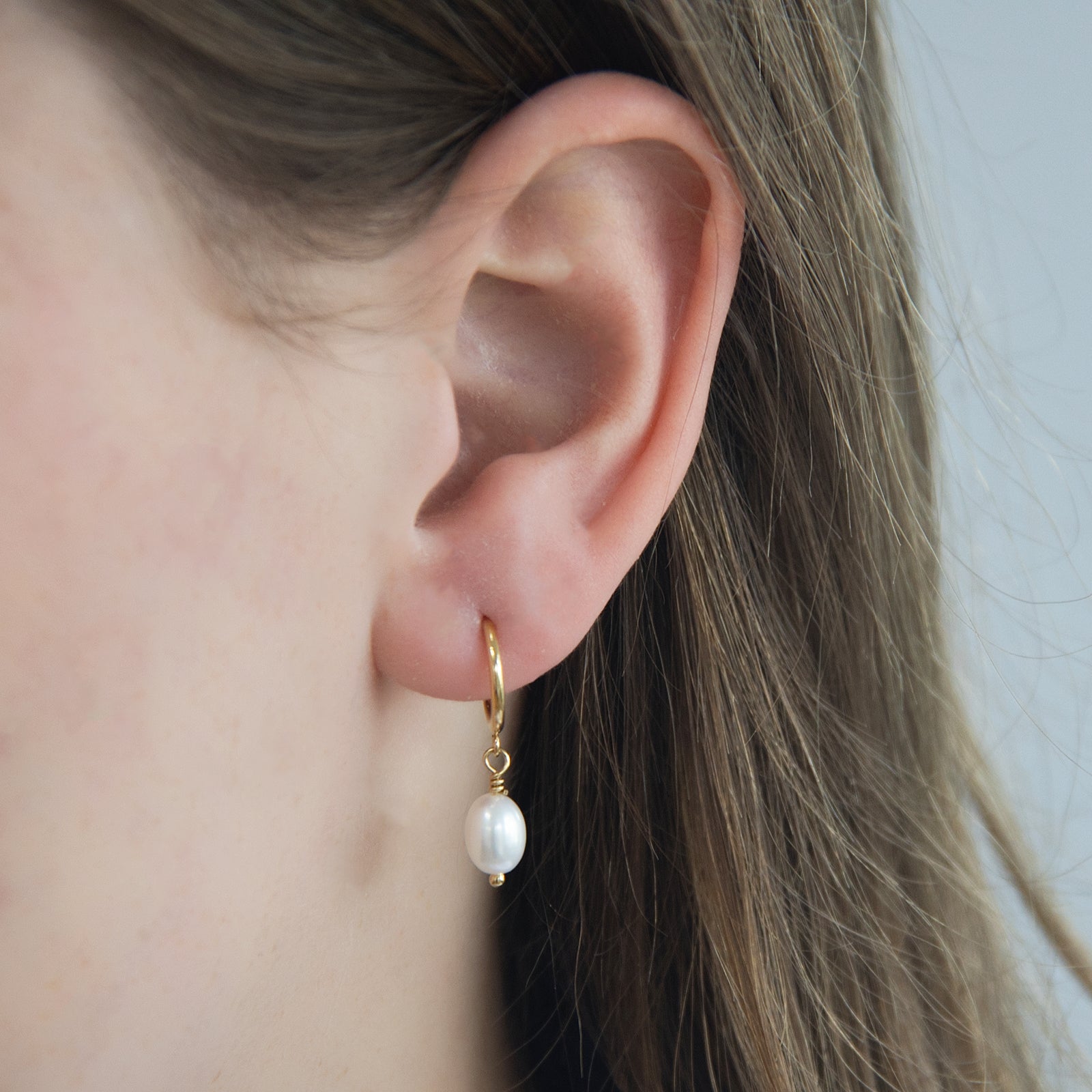 freshwater pearl hoop earrings gold worn by a model 