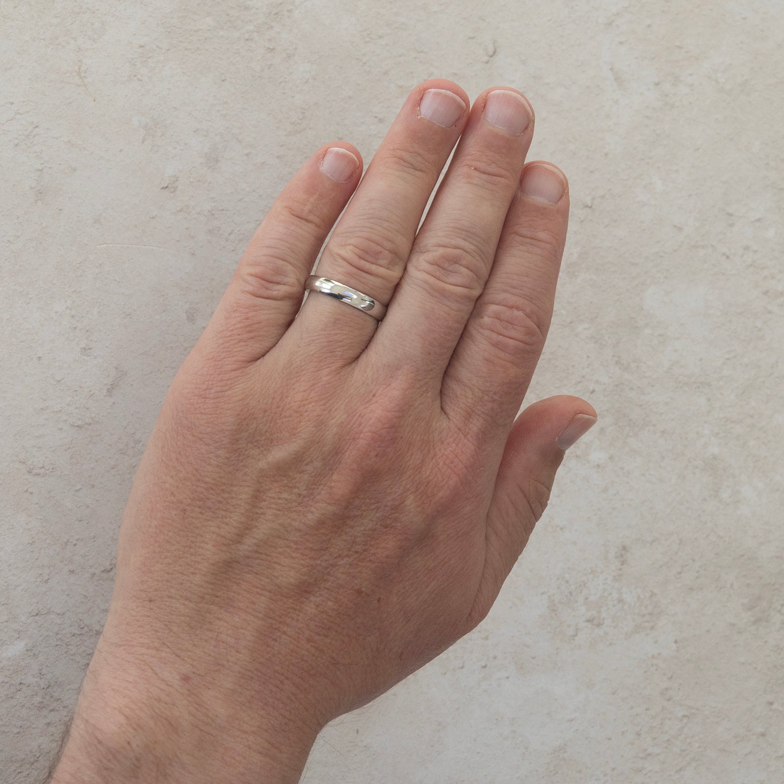 The For Keeps wedding ring worn on a model's hand — a plain polished 4mm men's ring