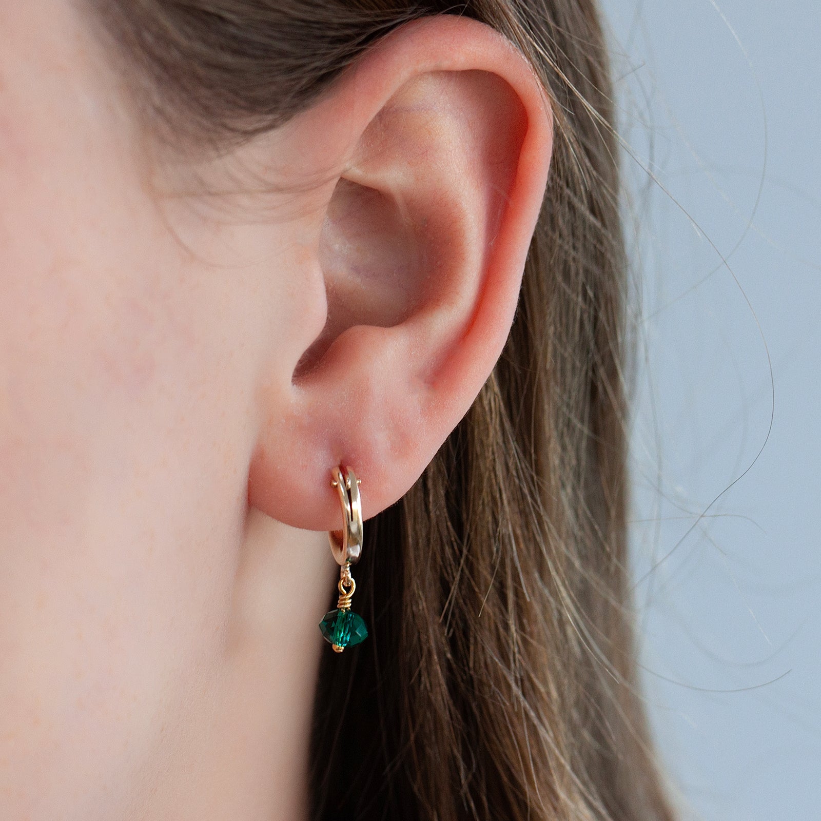 may birthstone hoop earring on a model close up 