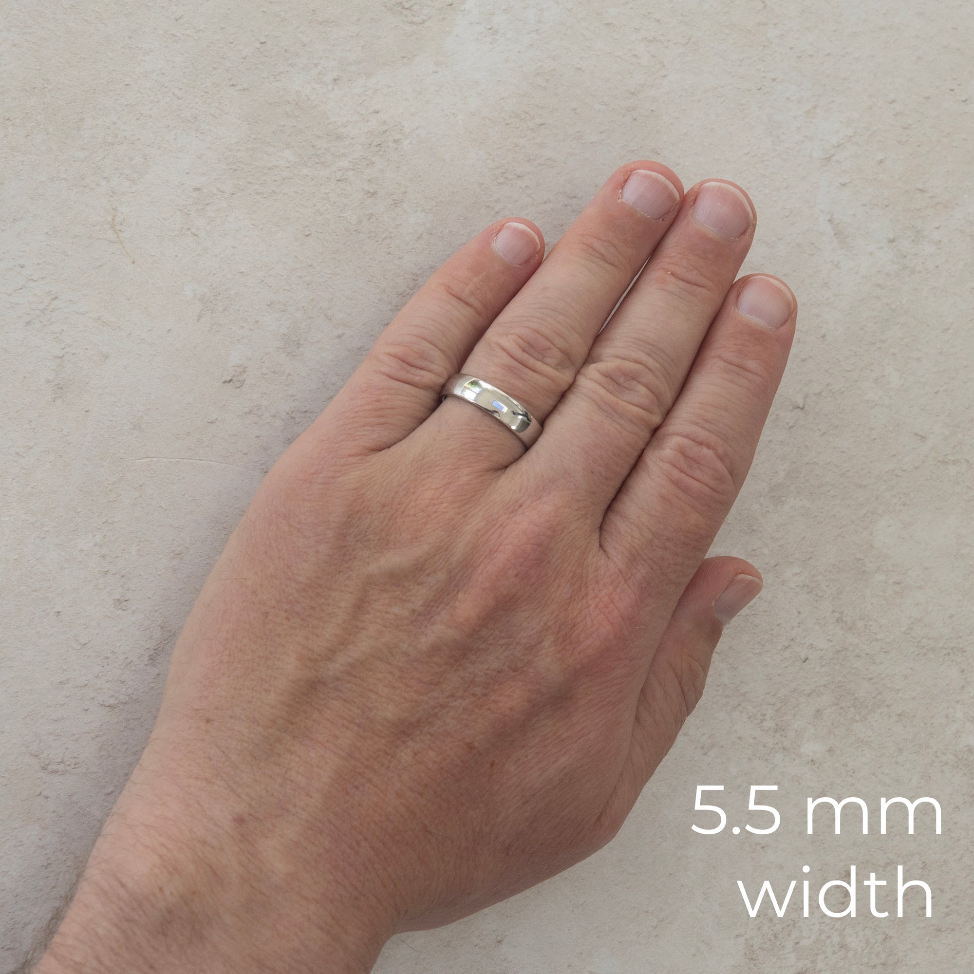 The Two of Us wedding ring worn on a model's hand — the 5.5mm width, plain polished with a comfort fit
