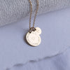 Close-up of Birthcoin necklace engraved with baby’s birth date, time, weight and height – custom birth keepsake necklace.