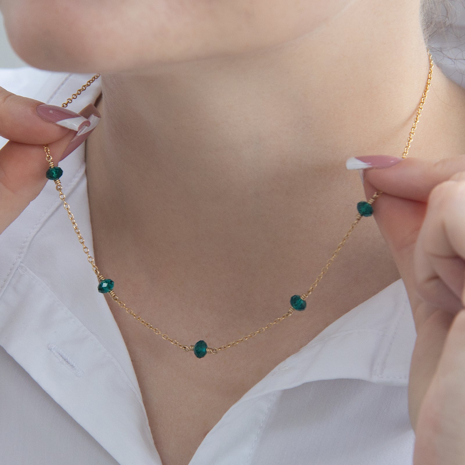 family birthstone necklace with five birthstones on a models neck 