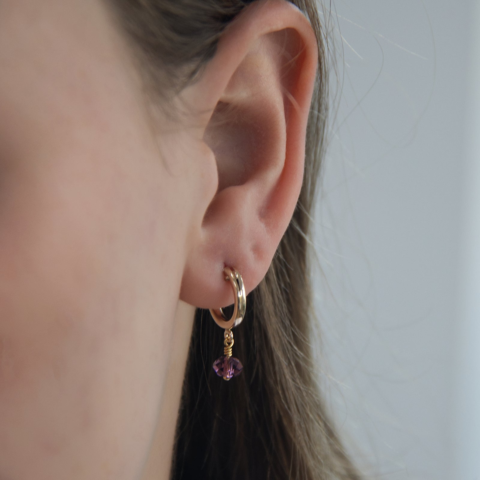 february birthstone hoop earrings close up on a model 