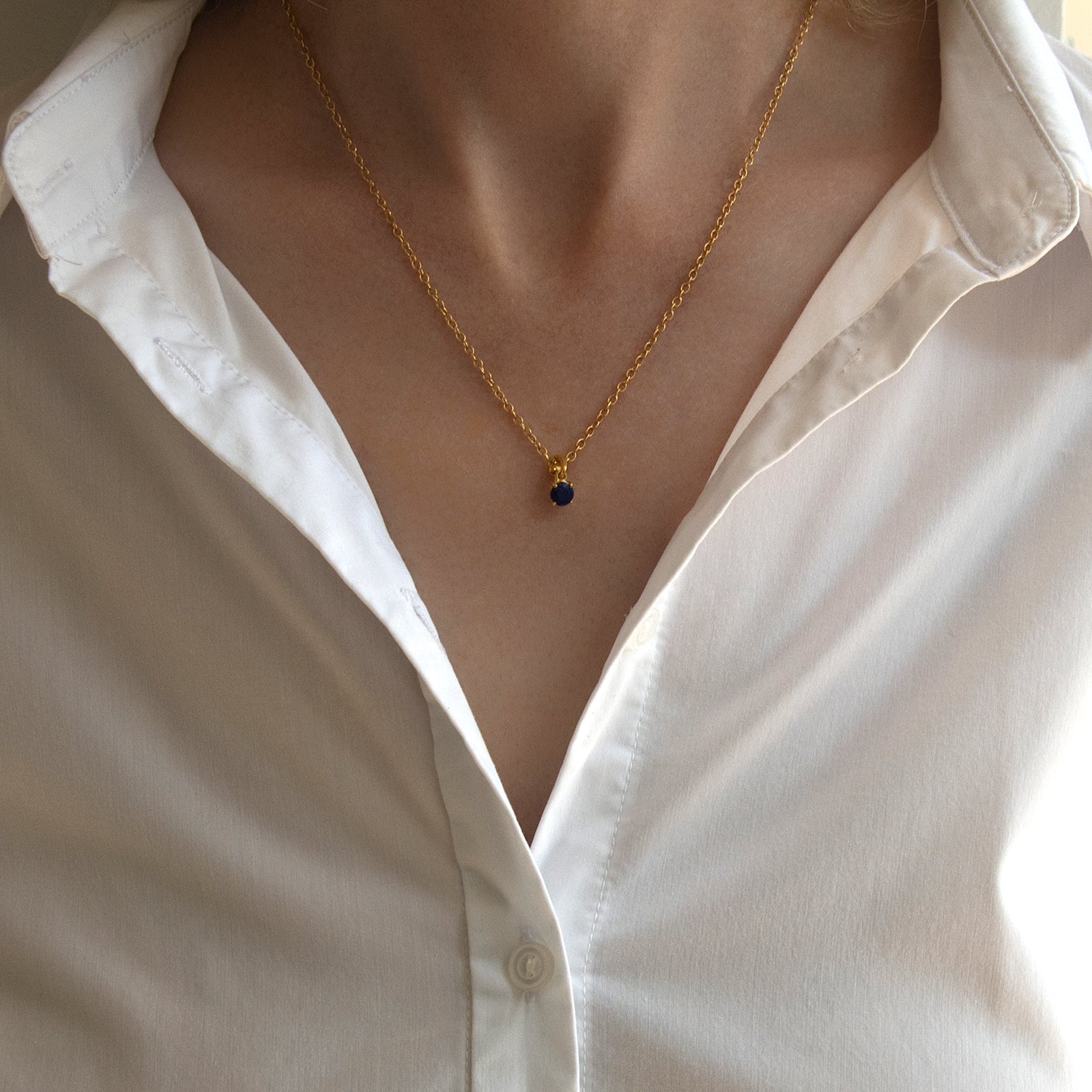 gold september birthstone pendant with lapis lazuli on a model 