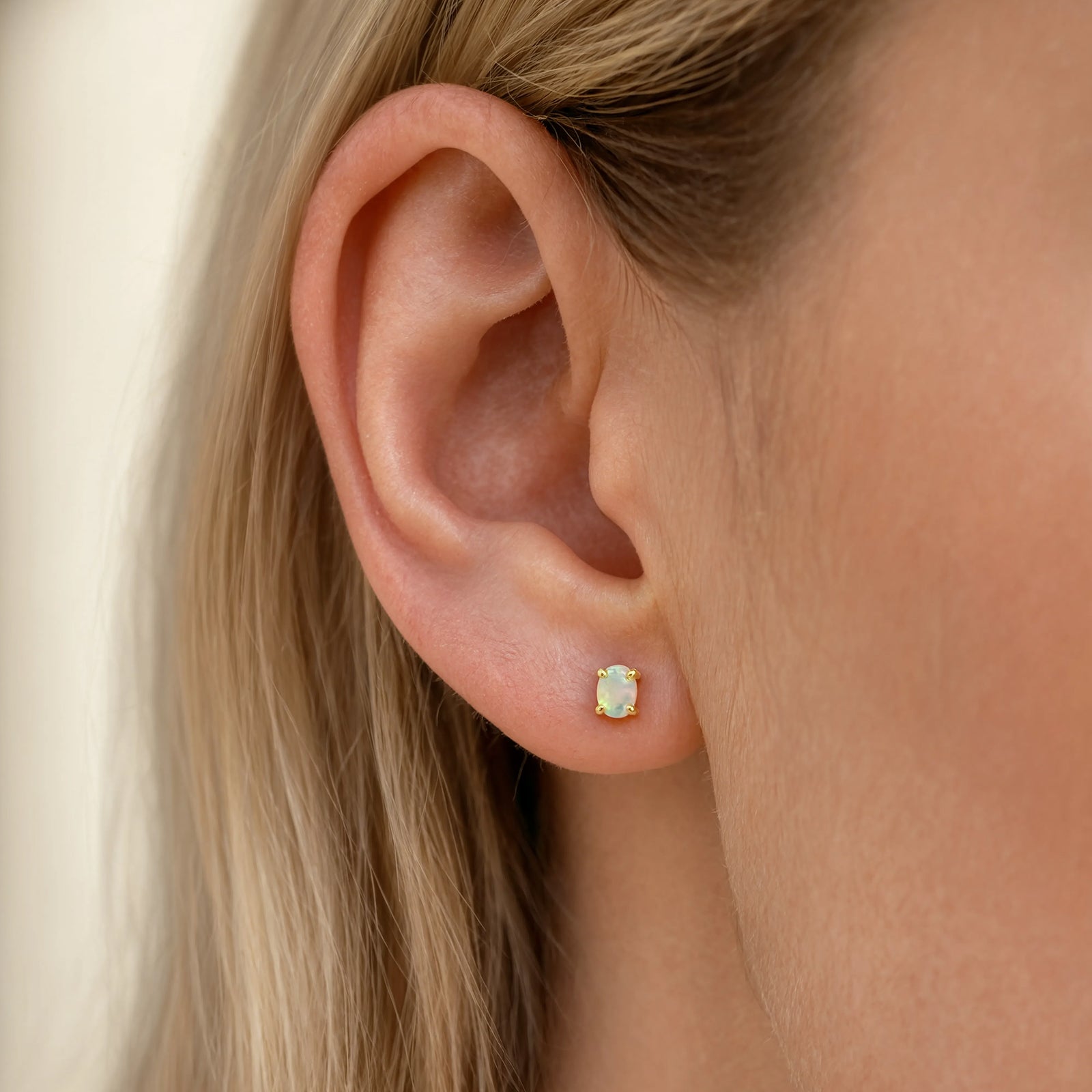 gold opal studs on a models ear final 