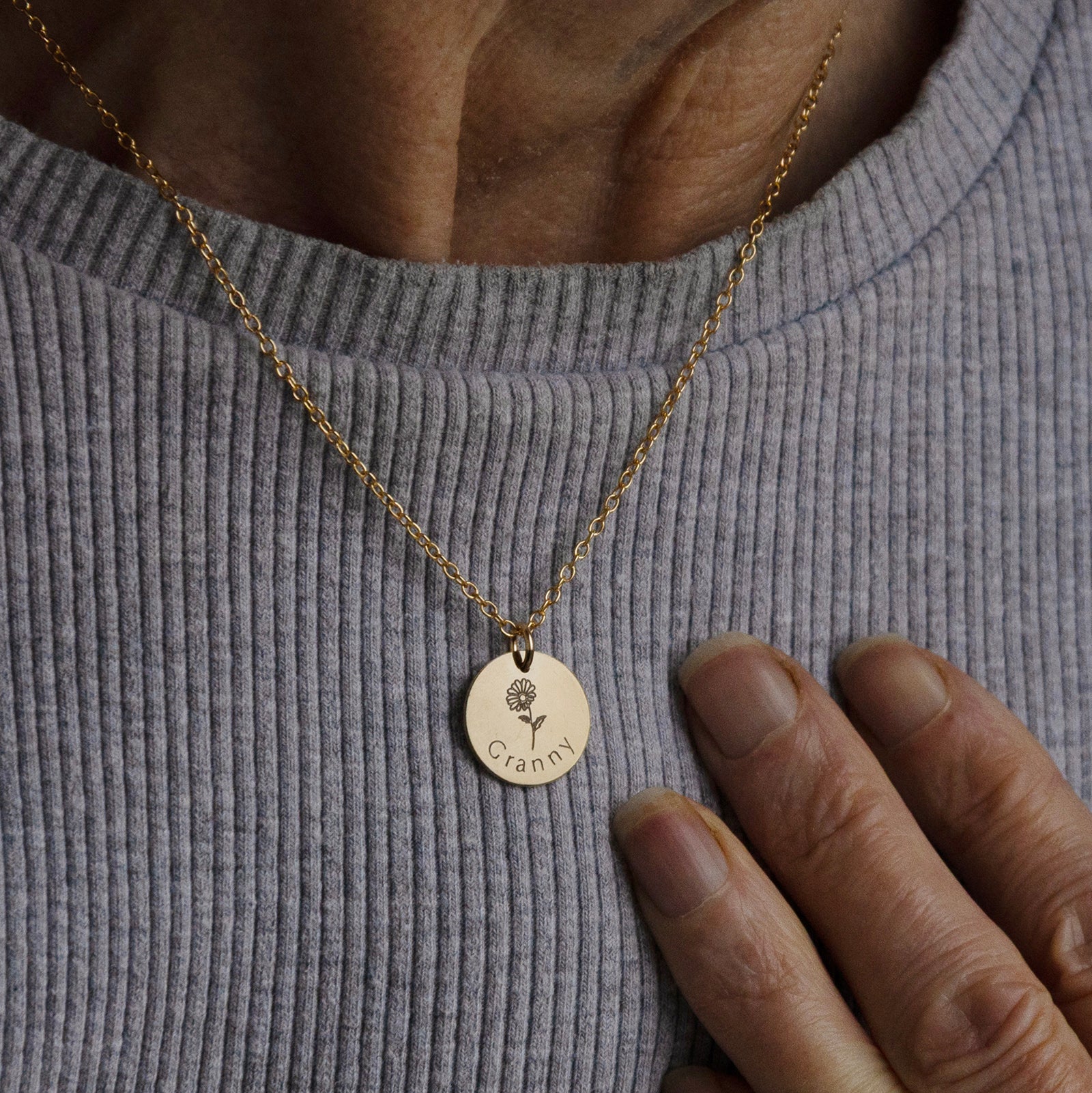 Front view of the personalised grandmother necklace worn on the neck of an older woman.