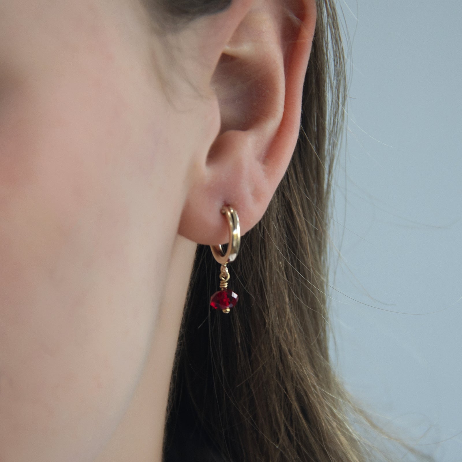 july birthstone hoop earring gold in an ear