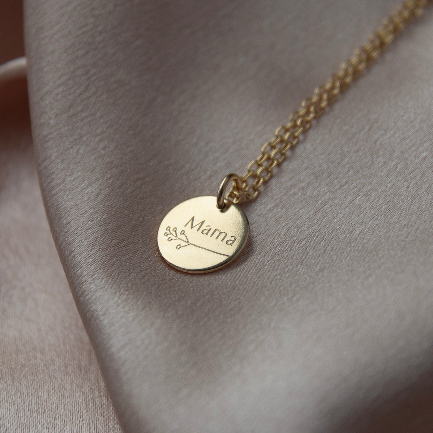 close up of botanical mama necklace in gold to show the engraving 