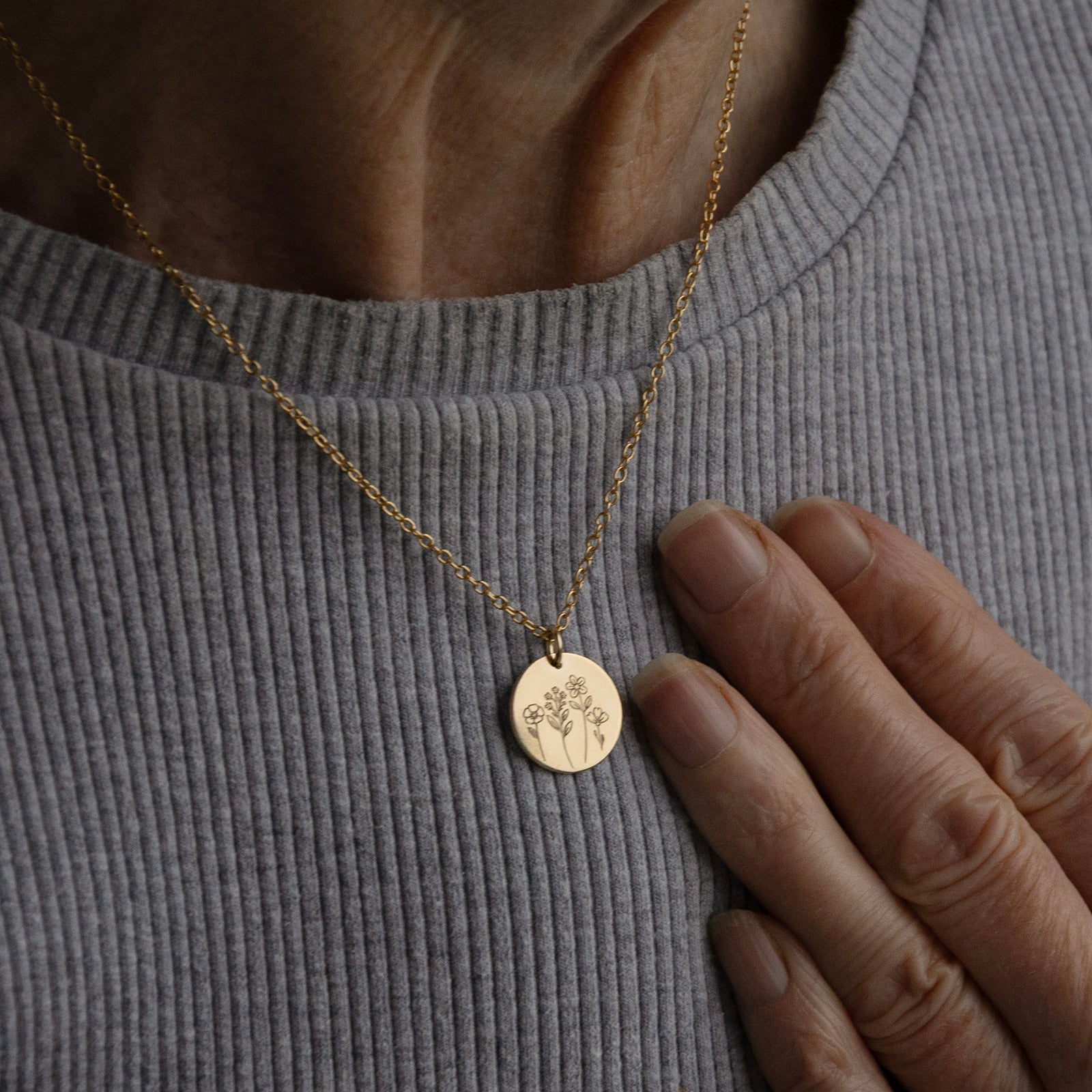 The Máthair Bloom Necklace worn on an older woman to show the size and scale of the pendant.