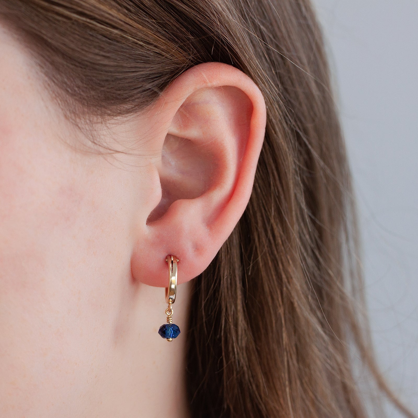 september birthstone hoop earrings close up on a models ears 