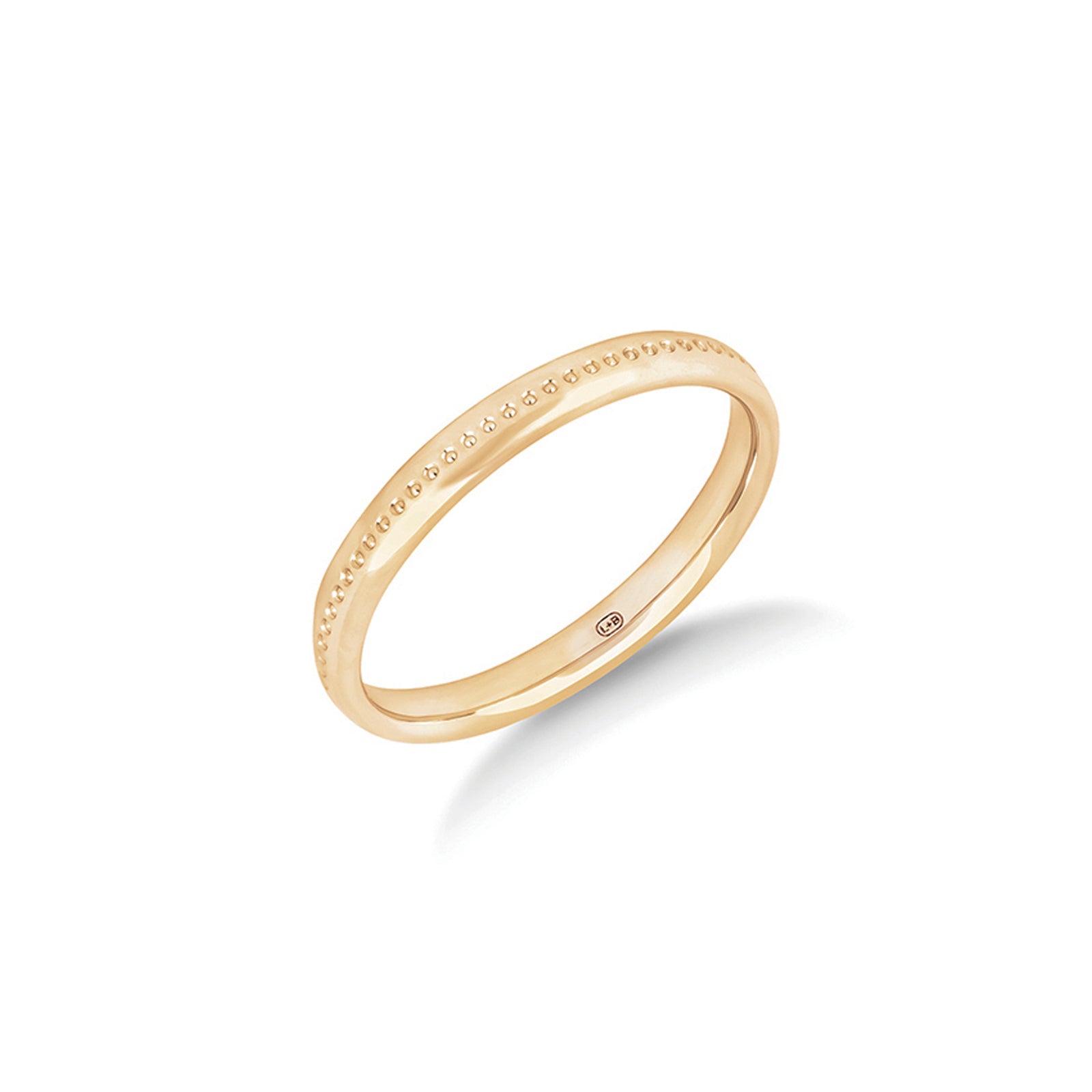 The First Light wedding ring in yellow gold, a slender 2.5mm ring with fine pearlised grooves running around it
