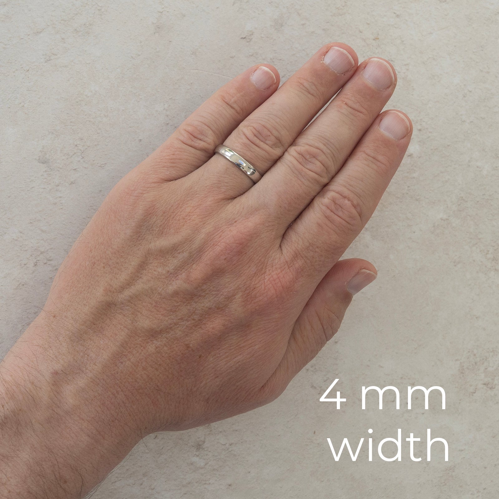 The Two of Us wedding ring worn on a model's hand — the 4mm width, plain polished with a comfort fit