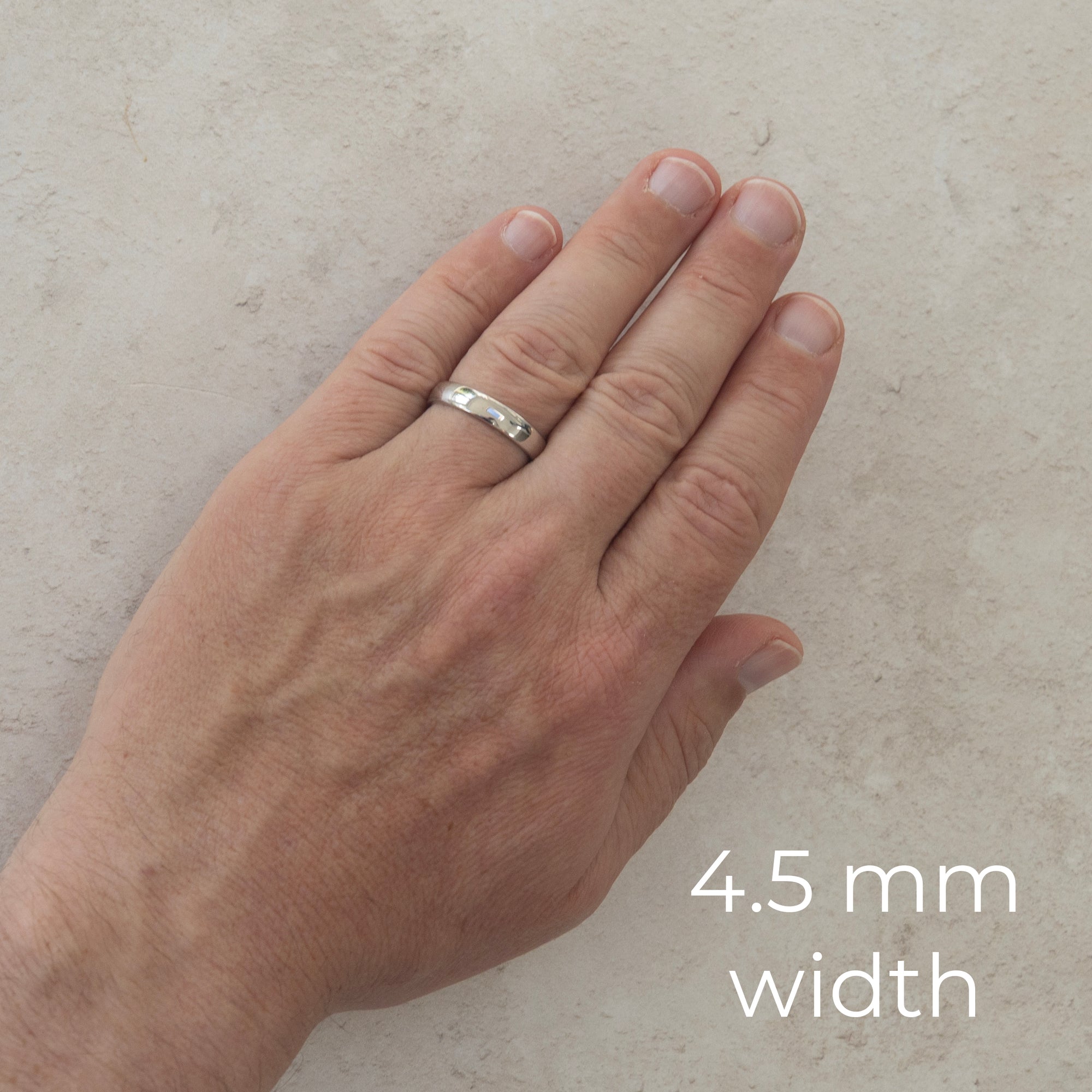 The Two of Us wedding ring worn on a model's hand — the 4.5mm width, plain polished with a comfort fit