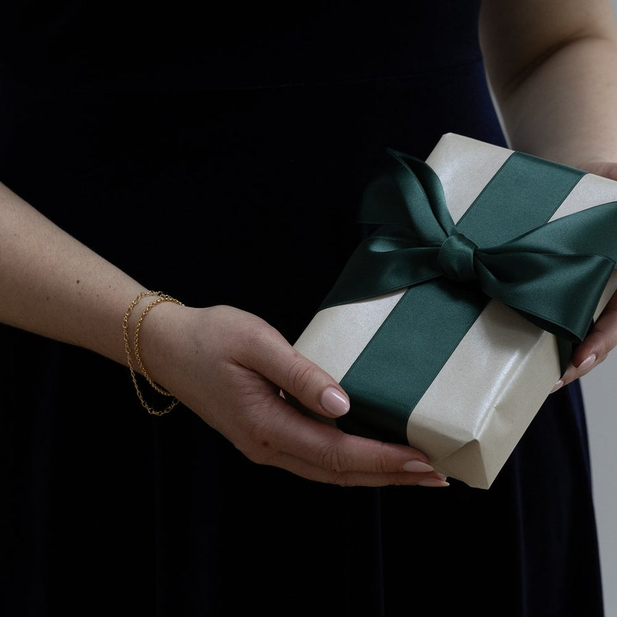 A gift box tied with an emerald ribbon